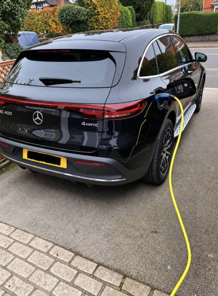 Mercedes EQC charging from a home EV charge point on a block-paved driveway