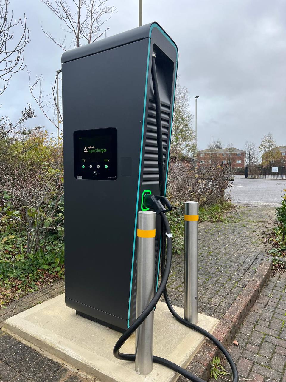 Alpitronic rapid DC charger installed on a commercial charging bay with protection bollards